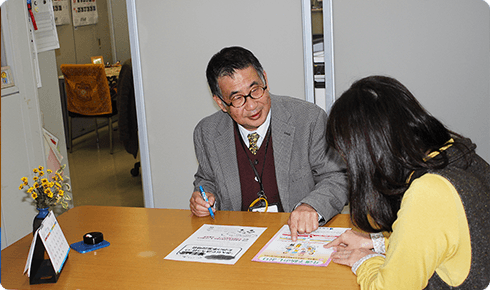 施設スタッフと入居者が卓上で活動・面談している風景